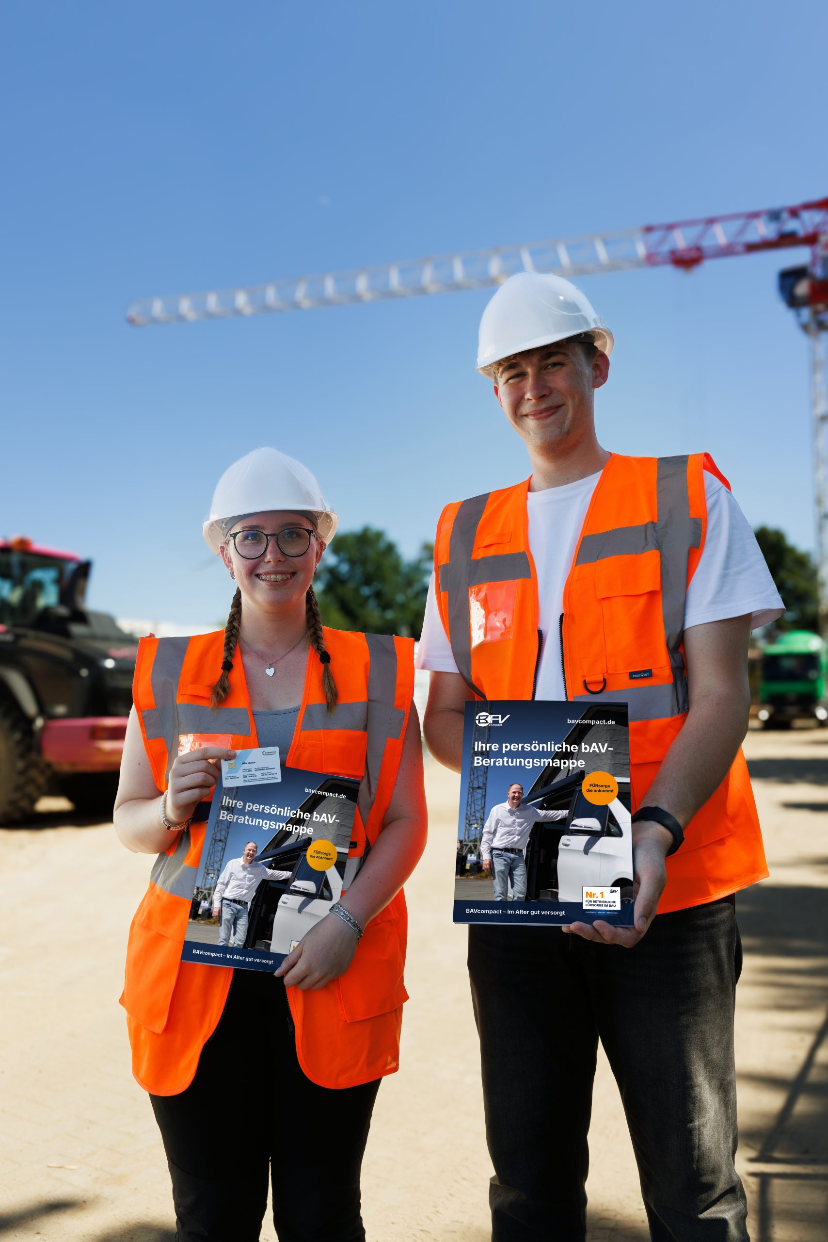 Zwei Personen mit orangenen Warnwesten und weißen Helmen stehen auf einer Baustelle und halten jeweils eine Beratungsmappe hoch. Im Hintergrund sind Baukräne und Fahrzeuge zu sehen.